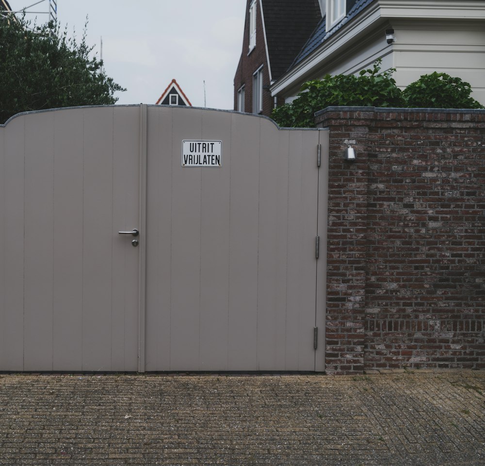 Closed grey double gate in a brick wall
